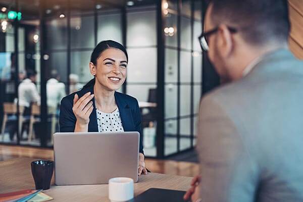 Smiling businesswoman talking to a colleague